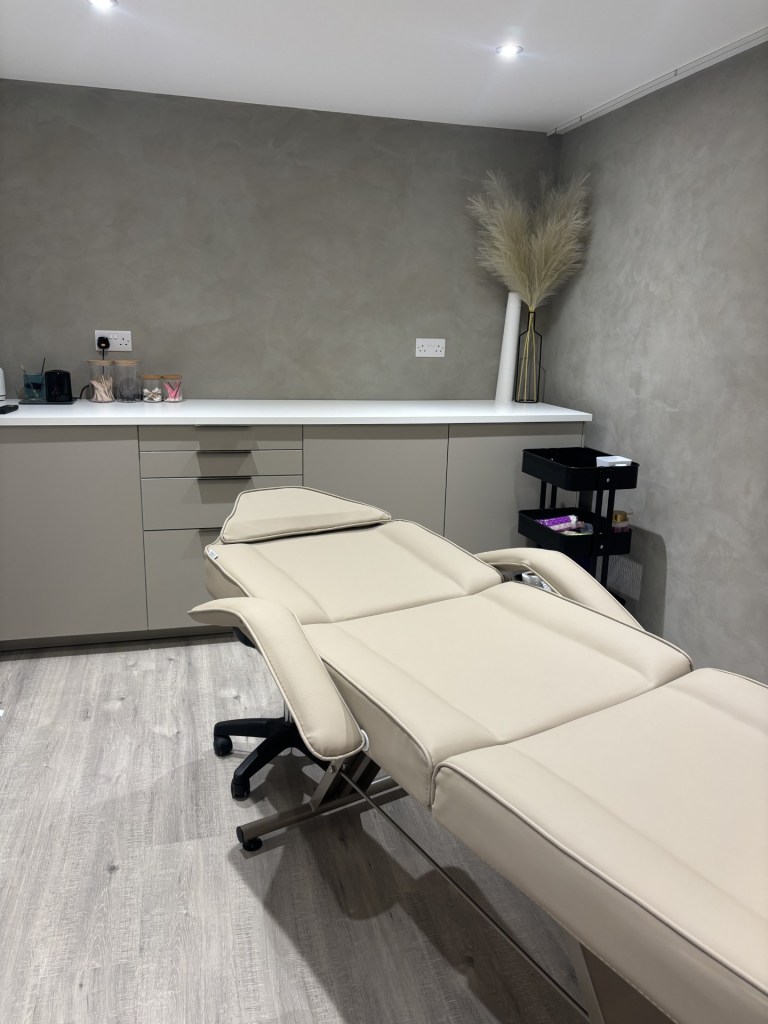 View of Novara treatment room, with cabinets and treatment bed in cream and beige.